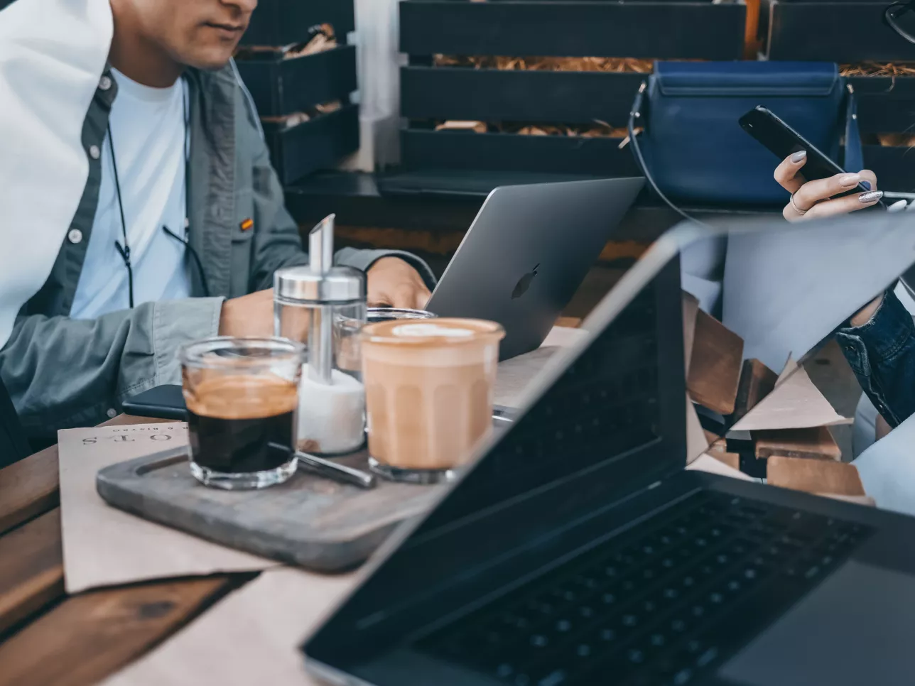 Man framför datorskärm dricker kaffe. Fotografi. 